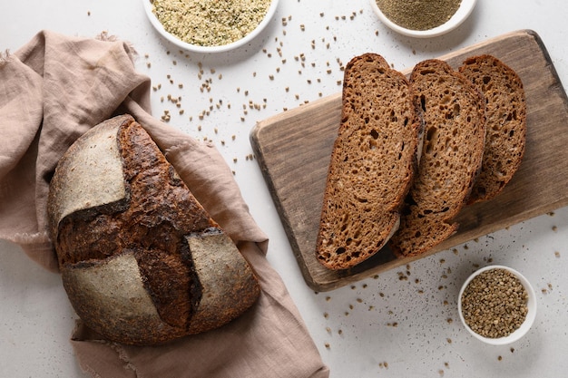 Loaf of freshly baked hemp bread and hempseeds on white background