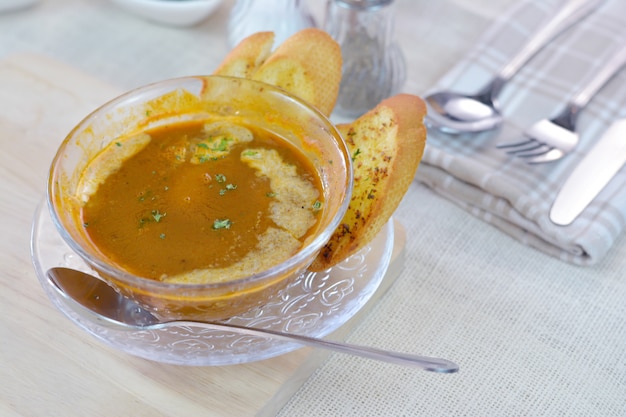 Lobster soup cream and on garlic bread wood cutting board