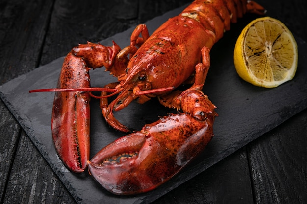 Lobster with lemon on black slate plate