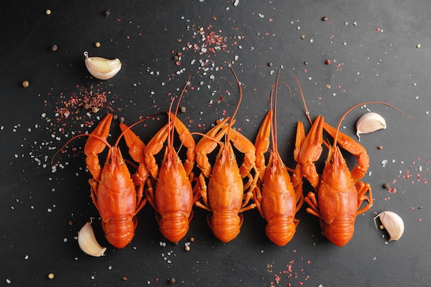 Lobsters with garlic and dry pepper on black background top view