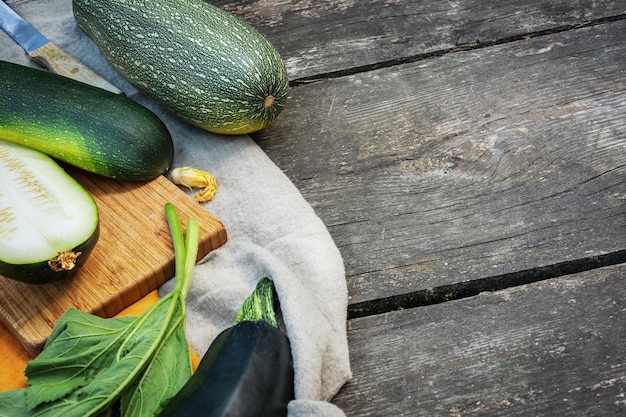 Local grown green zucchini on a wooden background with place for text