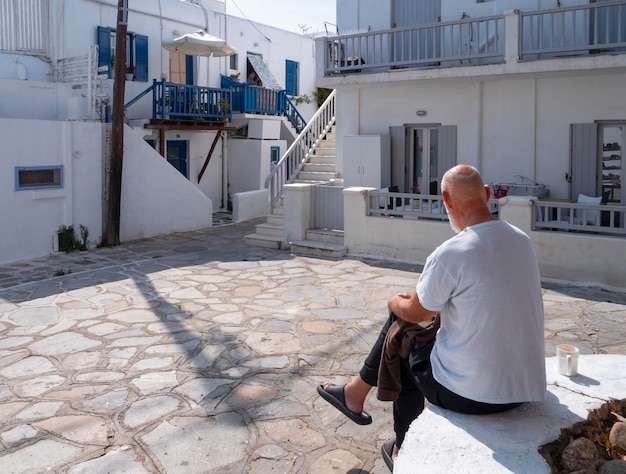 A local resident on square among houses of Cycladic architecture in Mykonos Greece