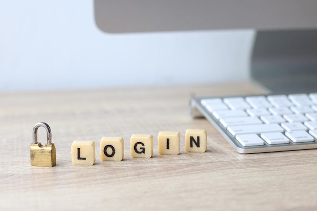 Lock and alphabet square tiles with the word login on office wooden desk. Cyber security concept.