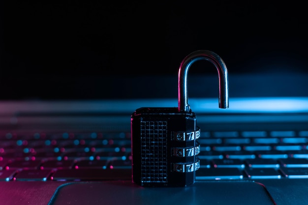 Lock on laptop as computer protection and cyber safety concept on neon background. Private data