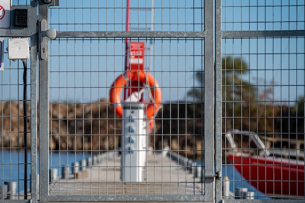 Locked iron security gate to the marina in the harbor shallow depth of field