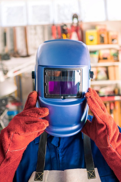 Locksmith in special clothes helmet and gloves to works in production