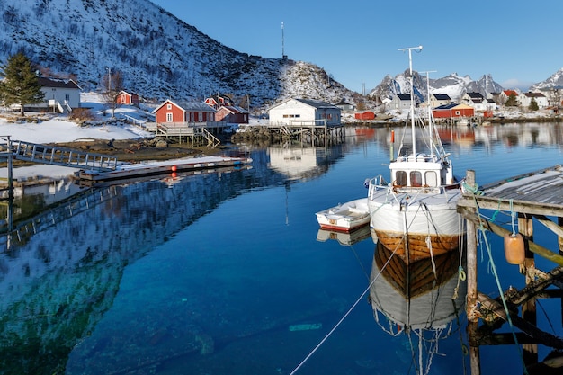 Lofoten islands Norway Fishing boats in the harbour red rorbu houses  snowy mountains