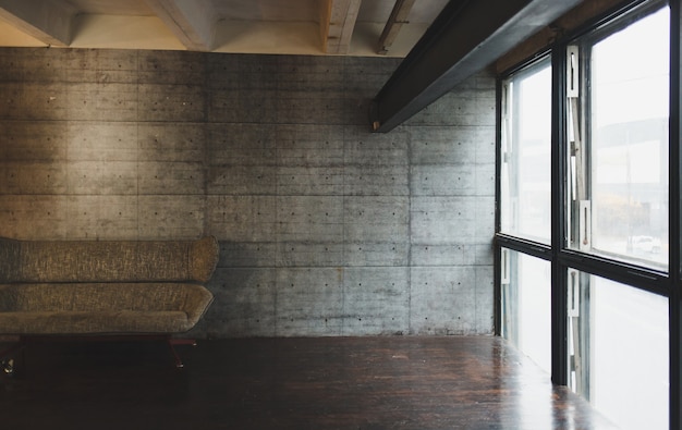 Photo loft interior with sofa in grey. brutal apartment