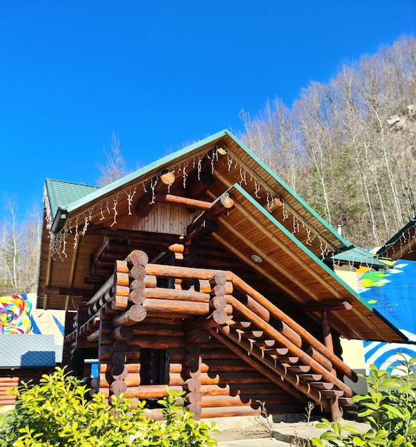 A log cabin with a green roof and a blue roof.