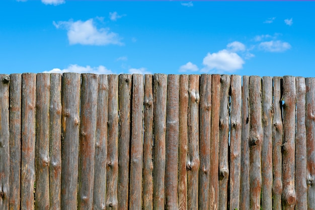 Log wooden fence. The texture of the old wooden fence. Wooden vintage background.