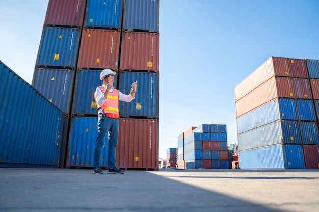 Logistics engineer control at the port, loading containers for trucks  export and importing logistic