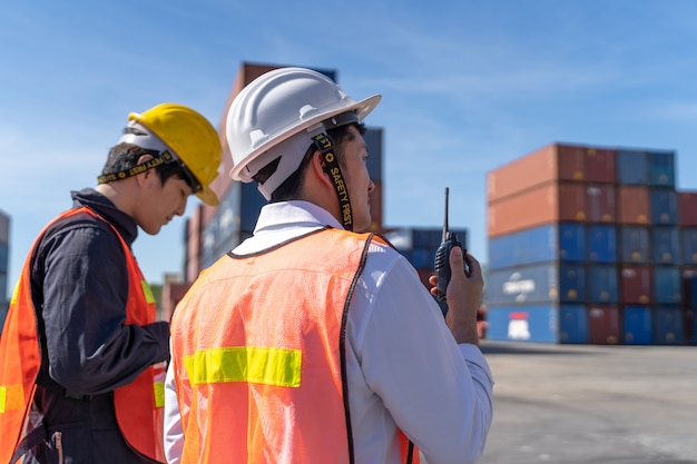 Logistics engineer control at the port, loading containers for trucks  export and importing logistic