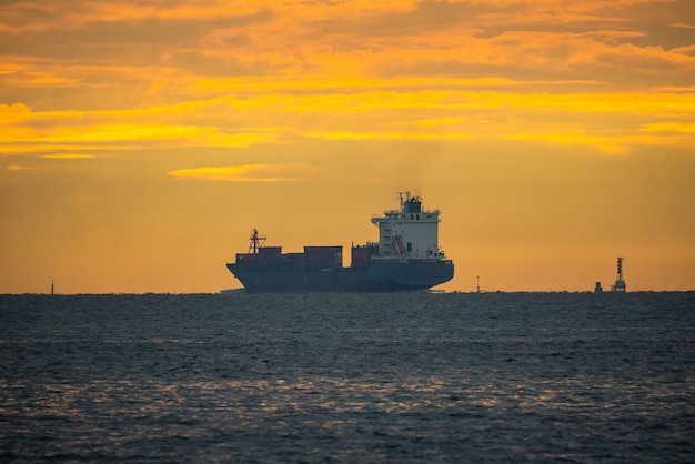 Logistics import export Container Cargo ship in seaport on sunset sky, Freight Transportation by container ship boat