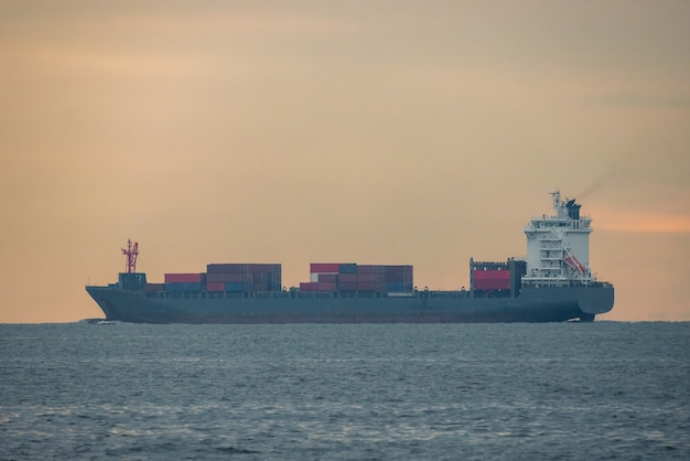 Logistics import export Container Cargo ship in seaport on sunset sky, Freight Transportation by container ship boat