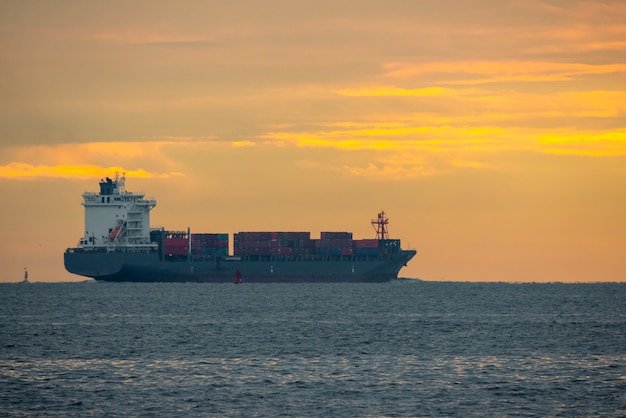 Logistics import export Container Cargo ship in seaport on sunset sky, Freight Transportation by container ship boat