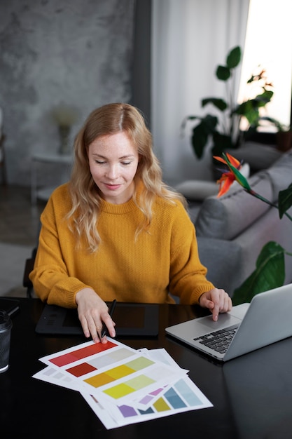 Logo designer working on her tablet connected to a laptop