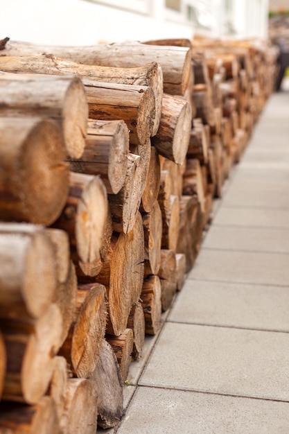 Logs woodpile near modern building house wall Selective focus