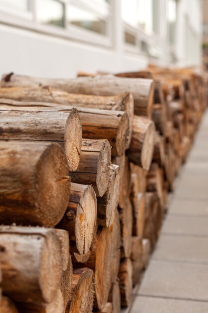 Photo logs woodpile near modern building house wall selective focus