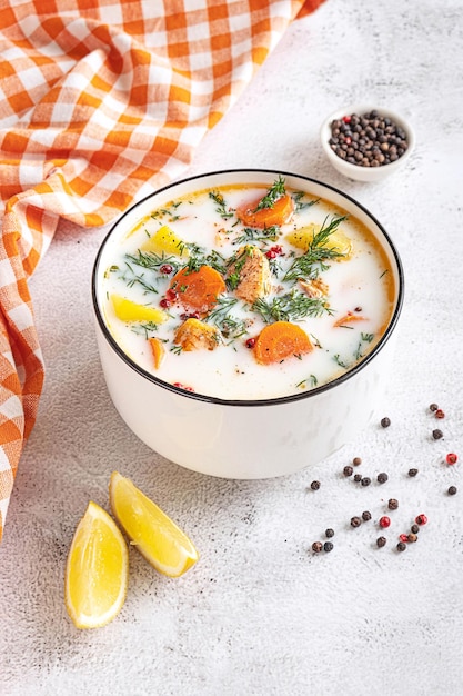 Lohikeitto Finnish traditional creamy salmon soup served in a white bowl Light grey tabletop