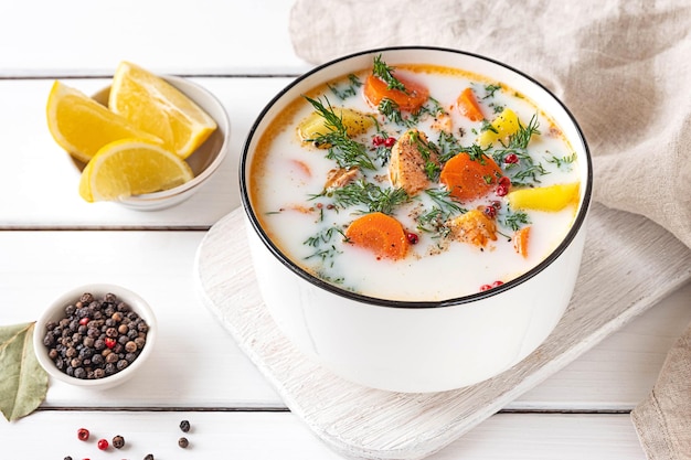 Lohikeitto Finnish traditional creamy salmon soup served in a white bowl White wooden tabletop