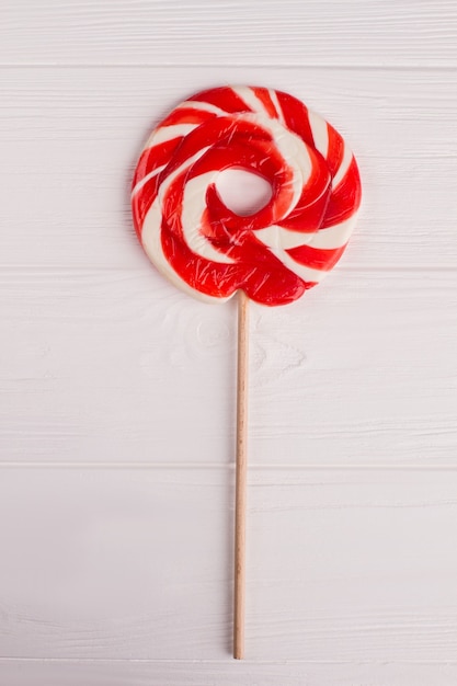 Lollipop candy on white. Red and white lollipop on stick. Top view