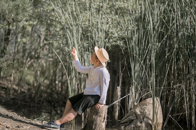 Lonely boy admiring the beauty of the summer lake in Greece Boy playing outside