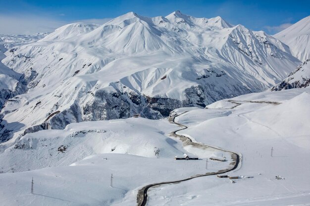 Lonely extreme road among white snow in high mountains