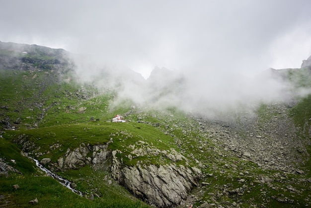 Lonely house isolated in green beautiful rocky meadow