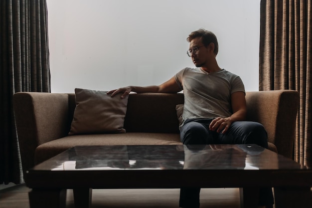 Lonely man sits on the sofa thinking of his lover