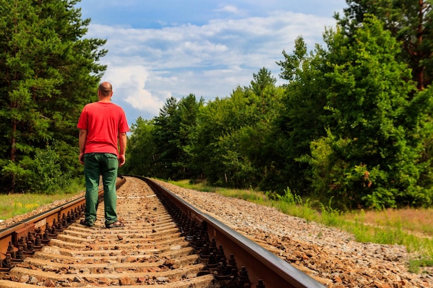 Lonely man walking on a railway track