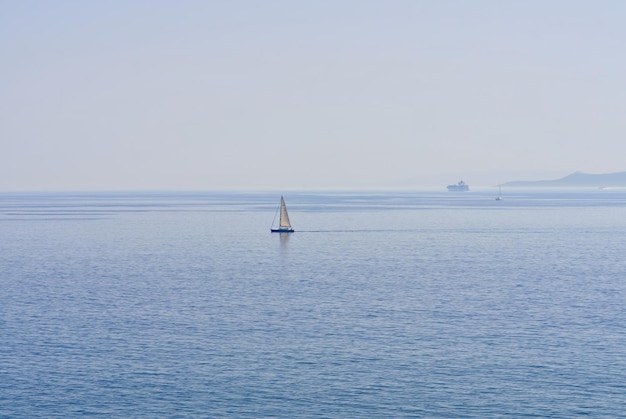 The lonely sailboat on the horizon in sea