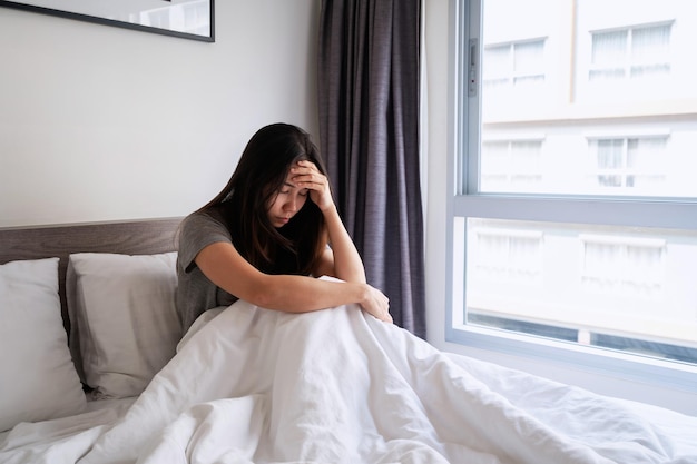 Lonely young woman feeling depressed and stressed sitting in the bedroom, Negative emotion and mental health concept