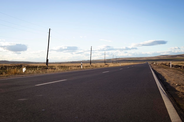 Long asphalt road and fields