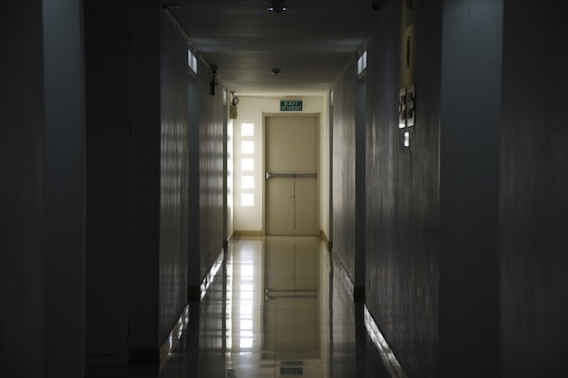 The long corridor in the building goes to the exit at night.