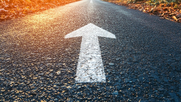 Photo long empty asphalt road stretches into the distance with a prominent arrow sign pointing forward