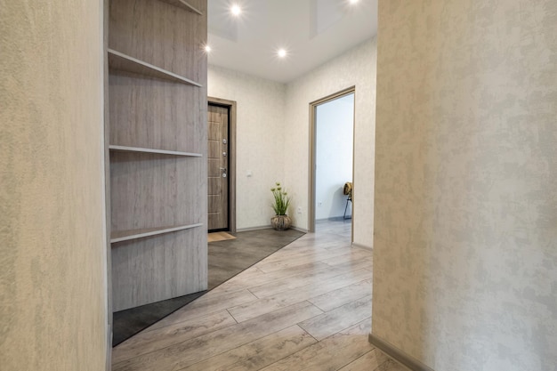 Long empty corridor with doors in interior of entrance hall of modern apartments