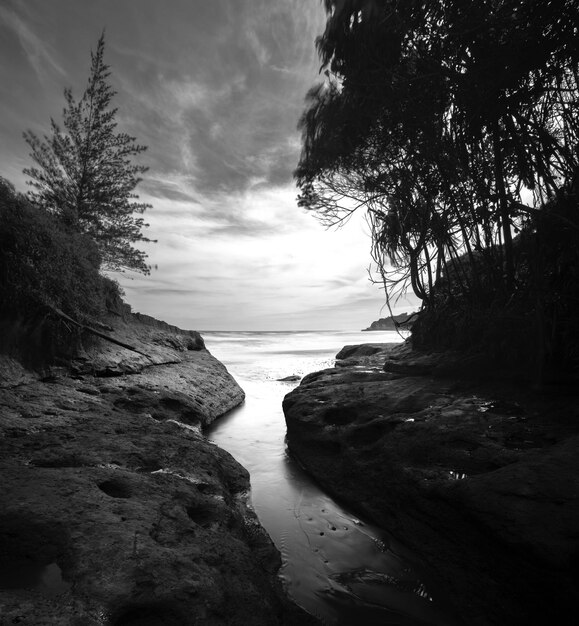 Long exposure art photo of the beach and high cliffs flanking the beautiful sea black and white