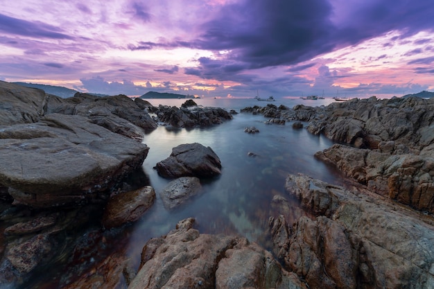 Long exposure image of Dramatic sky and wave seascape with rock in sunset scenery background