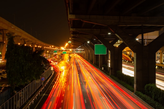 Long exposure photography showing light tracffic on highway in the city.