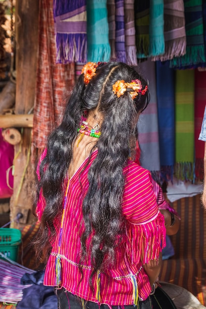 Long hair of long-necked Karen woman wearing tribal jewelry and brass rings on the neck at Chiang Rai, Thailand.