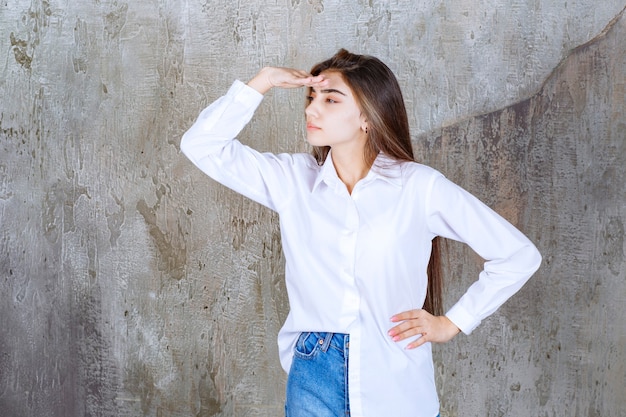 Long-haired beautiful girl in white blouse looking at somewhere