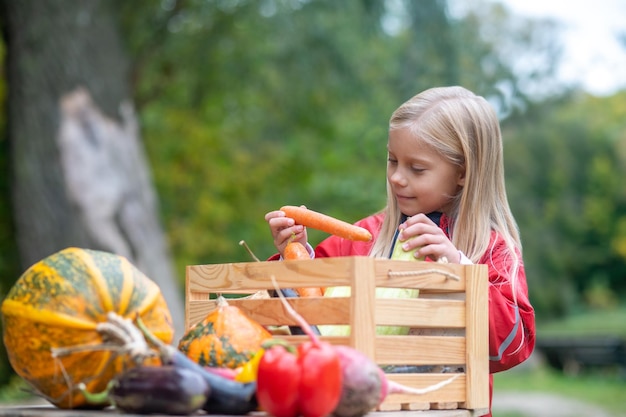 Long-haired blonde girl looking busy while sorting veggies