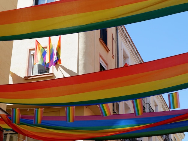 Long rainbow flags of gay community strung between buildings in Chueca district Madrid Spain