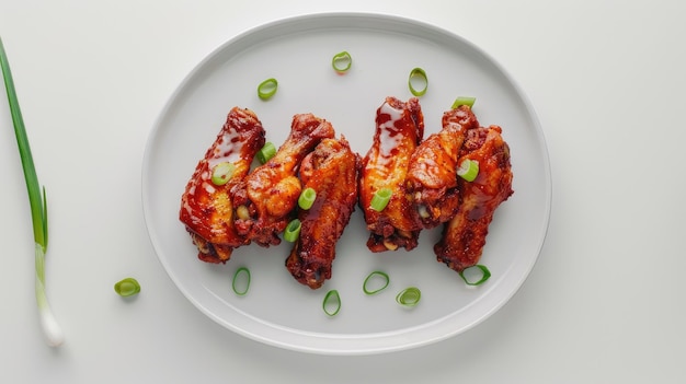 Photo a long rectangular white plate featuring succulent chicken wings coated white barbeque sauce perfectly arranged and garnished with freshly chopped green onions