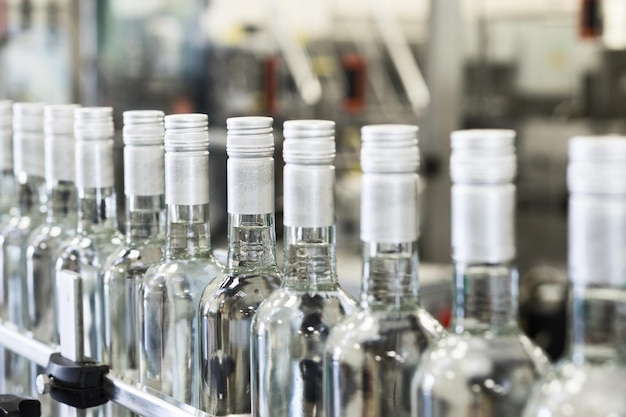 A long row of glass bottles on the conveyor Manufacture of alcoholic beverages