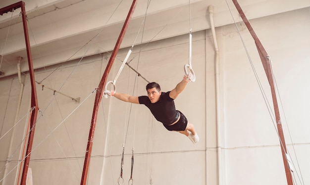 Long shot man training on gymnastics rings