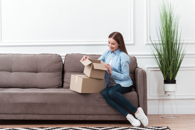 Long shot of woman opening a box