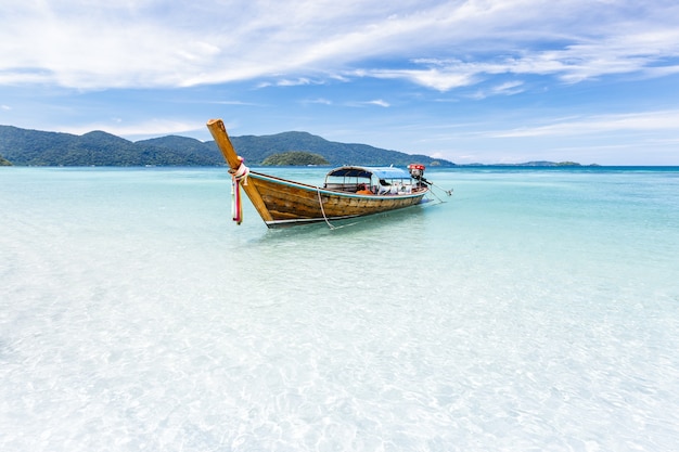 Long-tail boat floating on crystal clear sea water at tropical island, Andaman sea