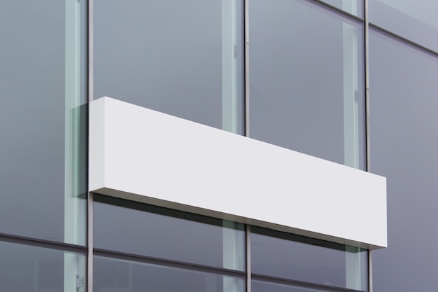 Long white shop banner sign board hanging on glass office building surface