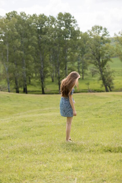 Photo longhaired girl in the summer in a dress from the back